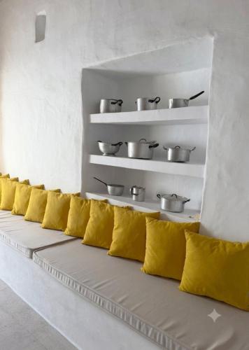 a row of yellow pillows sitting in a room at Kamara since 1900 in Archangelos
