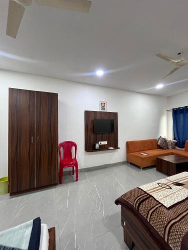a living room with a couch and a tv and a red chair at Jalsa hotel in Raipura