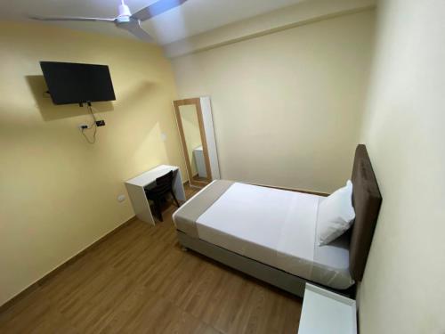 a bedroom with a bed and a tv on the wall at GRAND HOTEL ViLLA ROSA in Tingo María