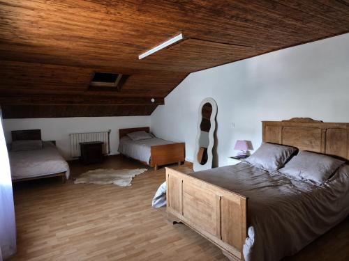 a bedroom with two beds and a wooden ceiling at La cabane de Claude in Fougerolles