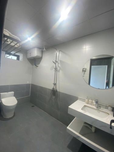 a bathroom with a toilet and a sink and a mirror at Công Đoàn Hotel in Hai Phong