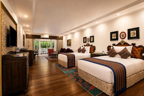 a hotel room with two beds and a television at MAYFAIR Himalayan Spa Resort in Kalimpong