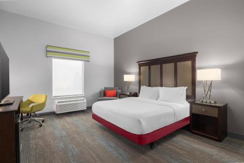 ein Schlafzimmer mit Bett, Schreibtisch und Fenster in der Unterkunft Hampton Inn Cotulla in Cotulla