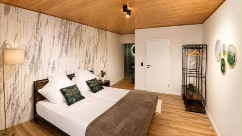 a bedroom with a white bed and a wooden wall at Villa Johannes in Warmensteinach