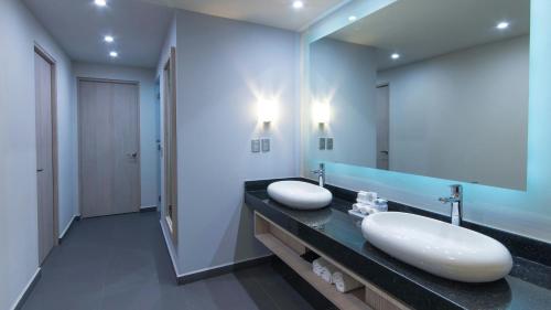 a bathroom with two sinks and a large mirror at Holiday Inn Express Mexico- Toreo by IHG in Mexico City
