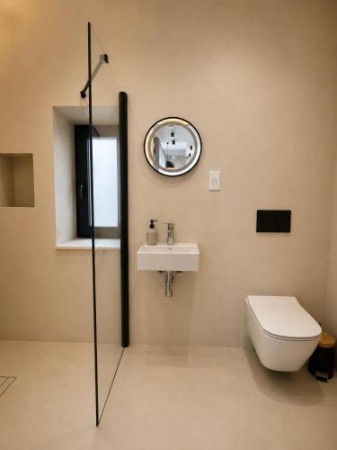 a bathroom with a sink and a toilet and a mirror at Modern Designer Apartment Private Yard in Hamrun