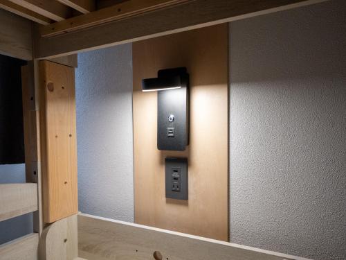 a mirror on a wall with a light on it at Guesthouse Sign in Kyoto