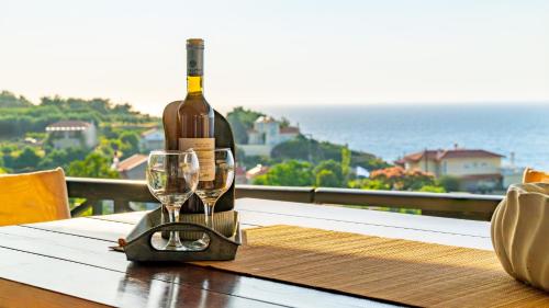 a bottle of wine sitting on a table with a glass at Agnanti Seaview Villas in Karlovasi