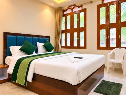 a bedroom with a large bed with green and white pillows at Hotel R GUEST HOUSE - NEAR KASHI VISHWANATH TEMPLE in Varanasi