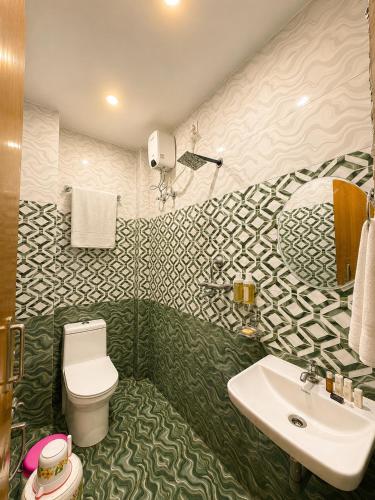 a bathroom with a toilet and a sink at Hotel R GUEST HOUSE - NEAR KASHI VISHWANATH TEMPLE in Varanasi