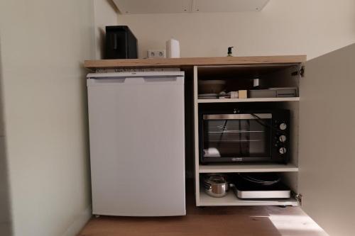 a kitchen with a white refrigerator and a microwave at MoselStudio Briedel - Sonnenterrasse und Komfort in Briedel