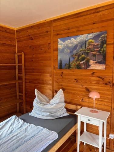 a room with a bed and a table and a painting at HerbergeZumBrieselang in Brieselang