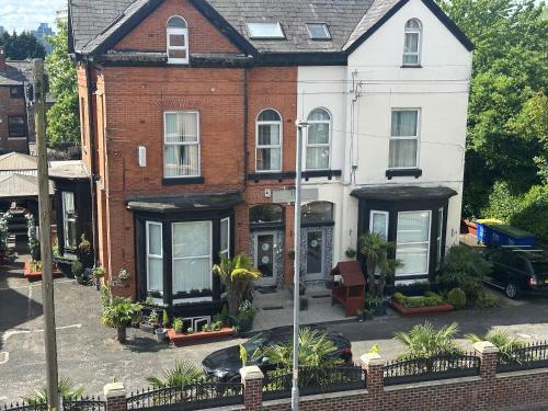a white and red brick house with black windows at Hendham House - Near Etihad Stadium, CoOp Live Arena, AO Arena, Piccadilly Train Station & Manchester City Centre in Manchester