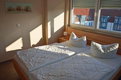 a bedroom with a bed with white sheets and pillows at Bella Casa 35 in Juliusruh
