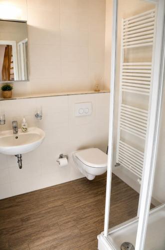 a white bathroom with a toilet and a sink at Bella Casa 35 in Juliusruh
