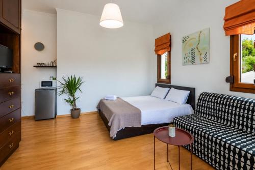 a living room with a bed and a couch at Suite Acropolis Serres Parking EV Next to Center in Serres