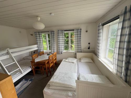 a bedroom with two beds and a table and chairs at Övertun in Hamburgsund