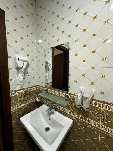 a bathroom with a sink and a mirror at Grand Turon Plaza Hotel in Tashkent