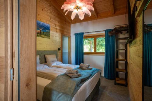 a bedroom in a log cabin with a bed and a chandelier at Schickster Sky Lodge und Chalet Rossi in Leutasch