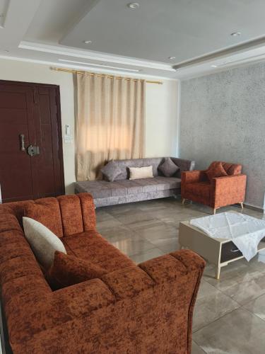 a living room with a couch and two chairs at Family Yahia in Ḩammām al Ghazzāz