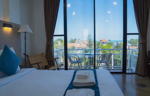 a bedroom with a bed and a view of a balcony at Serenity by Peace Garden, Koh Samui in Bangrak Beach