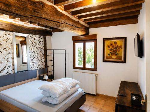 a bedroom with a bed in a room with wooden ceilings at Gîtes les Deux Vallées in Le Bois-Hellain