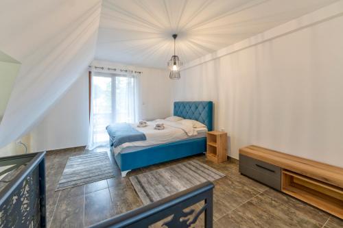 a bedroom with a blue bed and a window at Brvnara Mont 3 in Zlatibor