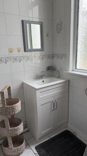 a white bathroom with a sink and a mirror at Rose Cottage Edinburgh in Edinburgh