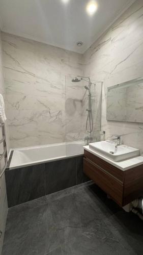 a bathroom with a bath tub and a sink at Monro in Odesa