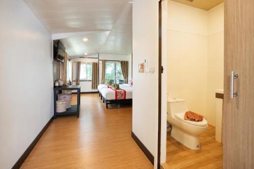 a bathroom with a toilet and a bedroom at Phi Phi Long Beach Resort & Villa in Phi Phi Islands