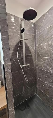 a bathroom with a black tiled wall with a lamp at Clos De La Ronziere Avec Jacuzzi in Soulages