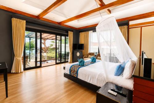 a bedroom with a bed with a mosquito net at Phi Phi Long Beach Resort & Villa in Phi Phi Islands