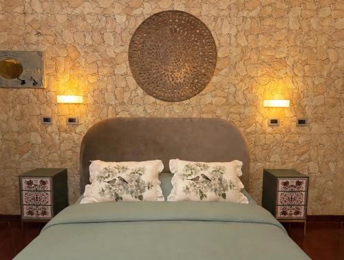 a bedroom with a bed with pillows and a stone wall at La Mammola Bed&Breakfast in Fabriano