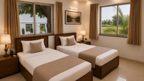 two beds in a hotel room with two windows at Heritage Garden in Bānsjora