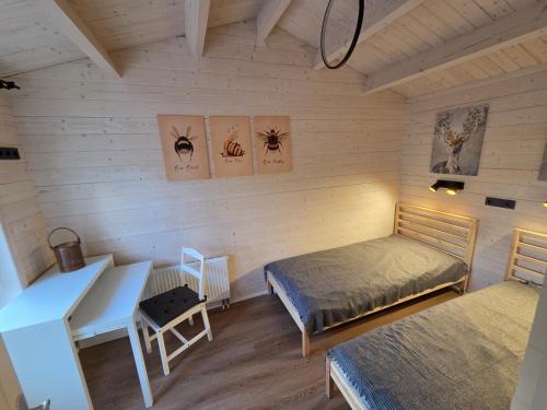 a room with two beds and a desk and a table at AMONG Nature Stay in Vilnius in Vilnius