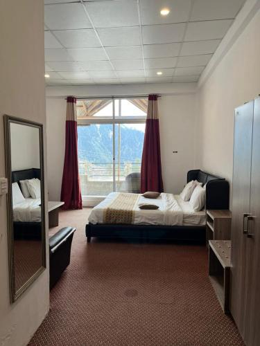 a bedroom with a bed and a large window at Sky view Resort Shogran in Shongran