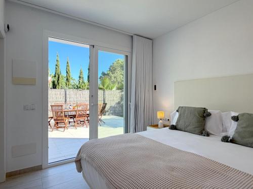 a bedroom with a bed and a patio with a table at Can Paola in Sant Josep