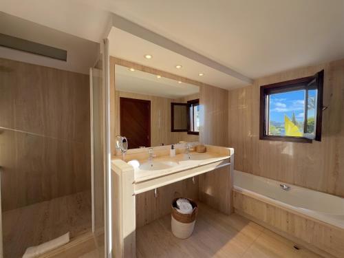 a bathroom with a sink and a tub and a mirror at Can Paola in Sant Josep