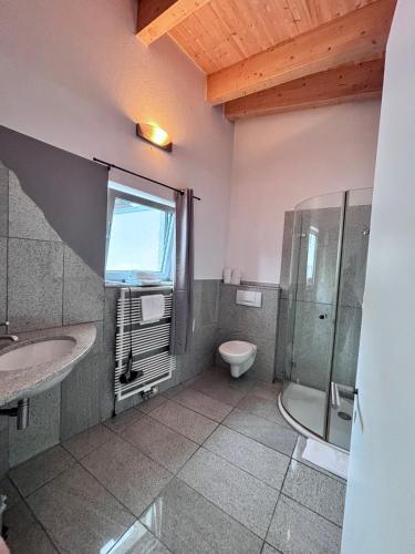 a bathroom with a toilet and a sink and a shower at PaderCityLoft Apartment Pfau in Paderborn