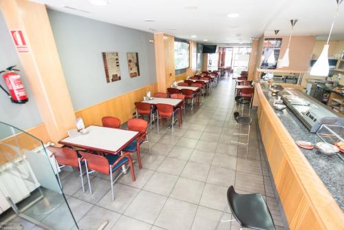 a row of tables and chairs in a restaurant at Hotel El Roble in Cervera de Pisuerga