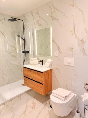 a bathroom with a sink and a toilet and a mirror at Résidence Bozzi in Grosseto-Prugna