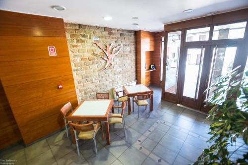 a restaurant with tables and chairs and a brick wall at Hotel El Roble in Cervera de Pisuerga