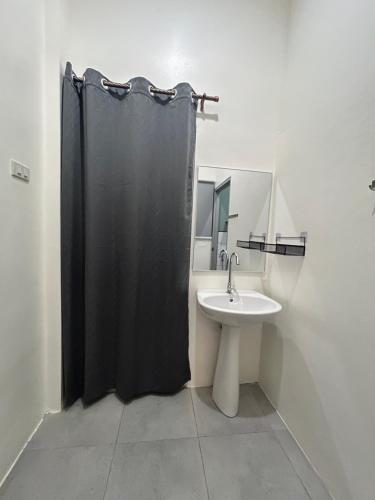 a bathroom with a black shower curtain and a sink at Island House Rentals 40 in Ko Samed