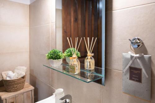 a bathroom with a glass shelf with plants and a mirror at Agnanti Seaview Villa in Karlovasi