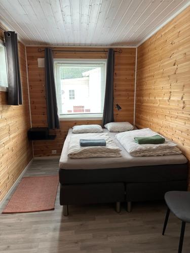 a bedroom with a bed in a room with a window at Løkvollstranda camping As in Samuelsberg