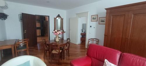 a living room with a table and a red couch at Suite IN PIAZZA in Poggio Renatico