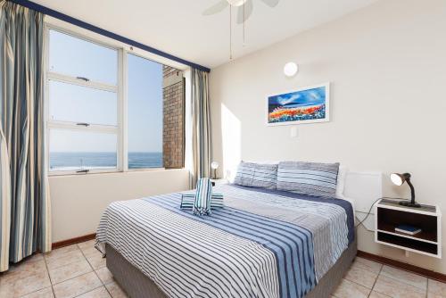 a bedroom with a bed with a view of the ocean at Peacehaven 108 in Scottburgh