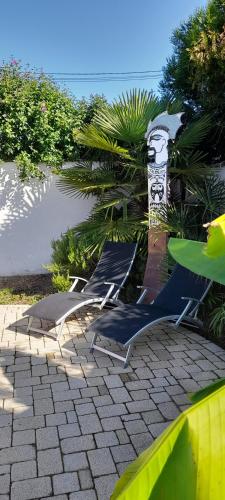 two lounge chairs sitting on a patio near the ocean at du Côté d'Agnès ! in Ostwald