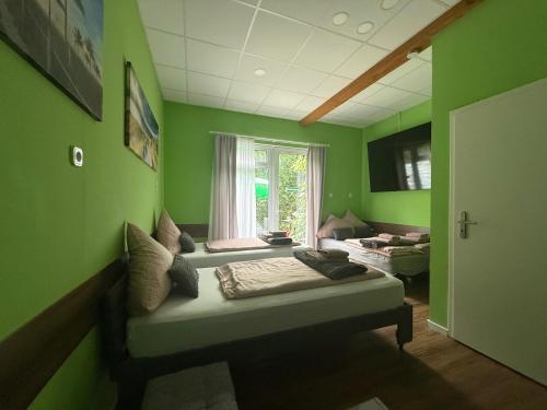 a green room with a bed and a window at Stern in Hückelhoven