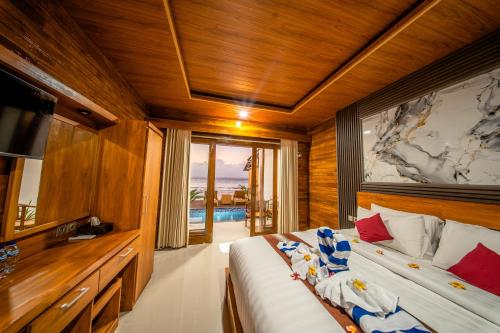 a bedroom with a large bed and a television at Sunrise Cottage in Nusa Penida